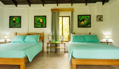 a bedroom with two beds and a window at Villa El Tucán in Bijagua