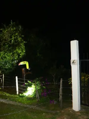 a fenced in yard with a water park at night at Villa El Tucán in Bijagua