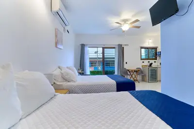 a hotel room with two beds and a kitchen at Apartaestudios La capital in San José