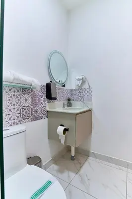 a bathroom with a sink and a mirror at Apartaestudios La capital in San José