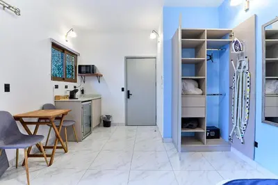 a kitchen with blue walls and a table and a door at Apartaestudios La capital in San José