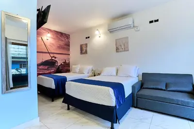 a hotel room with two beds and a couch at Apartaestudios La capital in San José