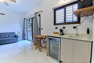 a kitchen and living room with a sink and a couch at Apartaestudios La capital in San José