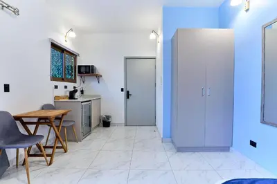 a kitchen with blue walls and a table and chairs at Apartaestudios La capital in San José