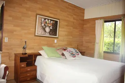a bedroom with a white bed and a wooden wall at Casa Amarilla San Carlos in Venecia