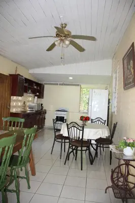 a dining room with a table and chairs and a ceiling fan at Casa Amarilla San Carlos in Venecia