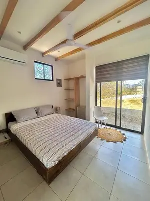 a bedroom with a large bed and a window at Cozy Cottage Hilltop near Conchal - Casa Vala in Matapalo