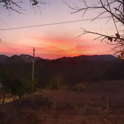 a sunset in a field with a telephone pole at Cozy Cottage Hilltop near Conchal - Casa Vala in Matapalo