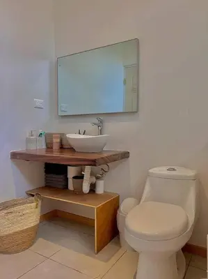 a bathroom with a white toilet and a sink at Cozy Cottage Hilltop near Conchal - Casa Vala in Matapalo
