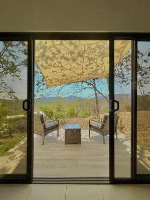 a view of a patio through a glass door at Cozy Cottage Hilltop near Conchal - Casa Vala in Matapalo