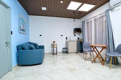 a living room with a blue couch and chairs at APARTAMENTO LA CAPITAL in San José