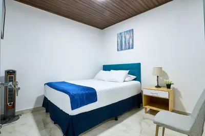 a bedroom with a bed and a chair at APARTAMENTO LA CAPITAL in San José