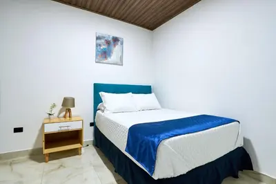 a bedroom with a bed with a blue and white bedspread at APARTAMENTO LA CAPITAL in San José