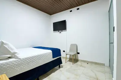 a bedroom with a bed and a tv on the wall at APARTAMENTO LA CAPITAL in San José
