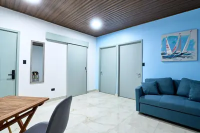 a living room with a blue couch and a table at APARTAMENTO LA CAPITAL in San José