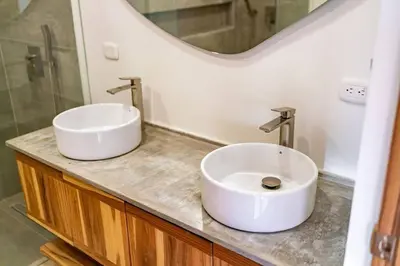 a bathroom with two sinks and a mirror at Hermosa Palms, Casa Lorenzo Beach Front Club House in Playa Hermosa