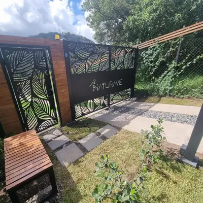 a sign with a bench next to a fence at NATURAVE - Into the woods - Mountain cabins in Monteverde Costa Rica