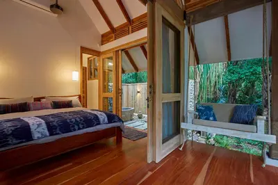 a bedroom with a bed and a large window at Casa Ananda a Bali Inspired Home in Nosara