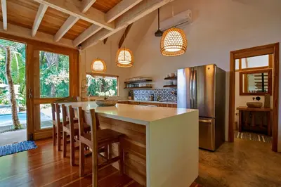 a kitchen with a large island with a refrigerator at Casa Ananda a Bali Inspired Home in Nosara