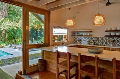 an open kitchen with a large island with wooden counter tops at Casa Ananda a Bali Inspired Home in Nosara
