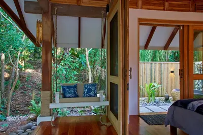 a bedroom with a door open to a garden at Casa Ananda a Bali Inspired Home in Nosara