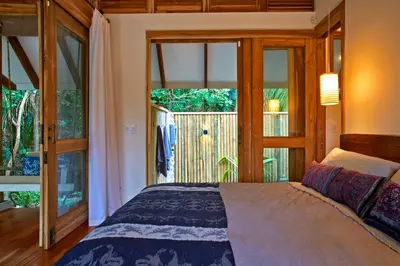 a bedroom with a bed and a large window at Casa Ananda a Bali Inspired Home in Nosara