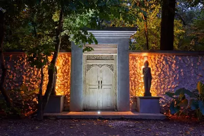 a statue standing in front of a door with lights at Casa Ananda a Bali Inspired Home in Nosara