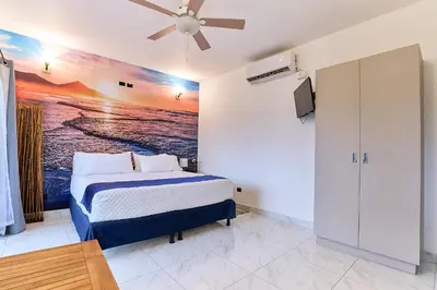 a bedroom with a bed and a painting on the wall at Apartaestudio La Capital in San José