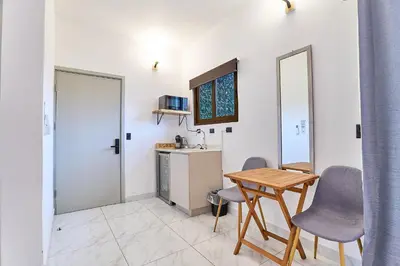 a kitchen with a table and chairs in a room at Apartaestudio La Capital in San José