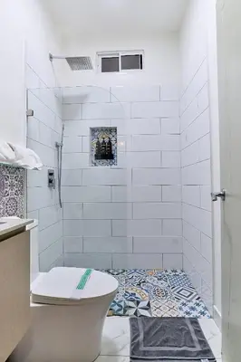 a white bathroom with a shower and a toilet at Apartaestudio La Capital in San José