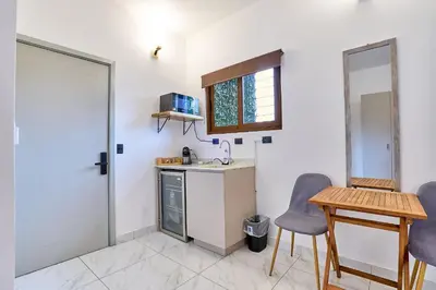 a small kitchen with a table and two chairs at Apartaestudio La Capital in San José