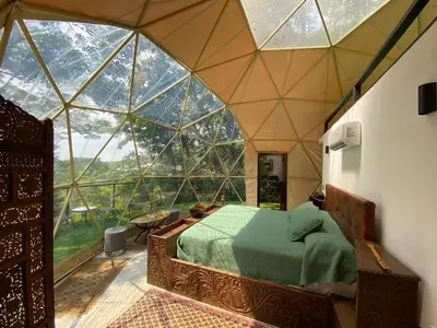 a bedroom in a room with a large glass window at Way To Heaven Glamping in Monteverde Costa Rica