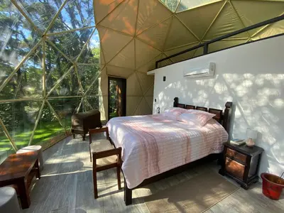 a bedroom with a bed and a large window at Way To Heaven Glamping in Monteverde Costa Rica