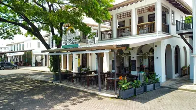 a building with tables and chairs on a street at Beachfront Condo - your Oasis with pool and Wi-Fi in Bejuco