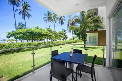 a table and chairs on a balcony with a view of the ocean at Beachfront Condo - your Oasis with pool and Wi-Fi in Bejuco