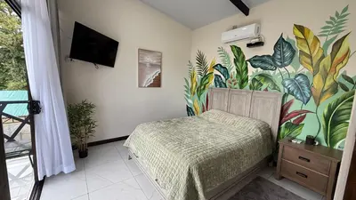 a bedroom with a bed and a mural of plants at Villa ViVe in Florencia