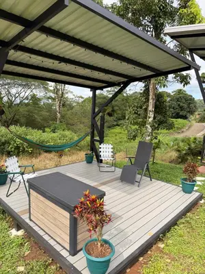 a wooden deck with a gazebo with chairs and a hammock at Villa ViVe in Florencia