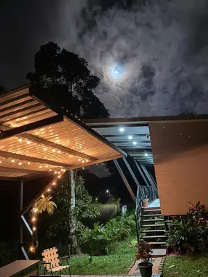a patio with a wooden pergola at night at Villa ViVe in Florencia