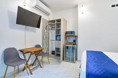 a bedroom with a bed and a table and chairs at Apartaestudios La capital in San José
