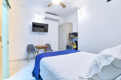 a bedroom with a bed and a table and a tv at Apartaestudios La capital in San José