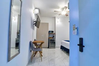 a room with a bed and a table and a mirror at Apartaestudios La capital in San José