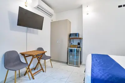 a bedroom with a bed and a table and chairs at Apartaestudios La capital in San José