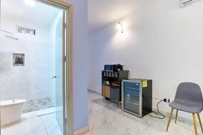 a bathroom with a shower and a chair and a sink at Apartaestudios La capital in San José