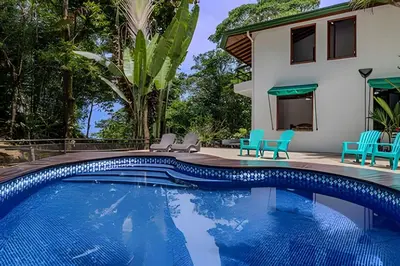a villa with a swimming pool and a house at The Jungle Inn in Dominicalito