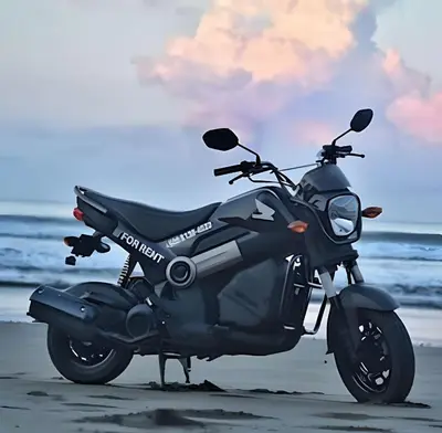 a motorcycle parked on the beach near the ocean at The Jungle Inn in Dominicalito