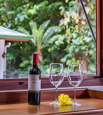 a bottle of wine and two wine glasses on a table at The Jungle Inn in Dominicalito