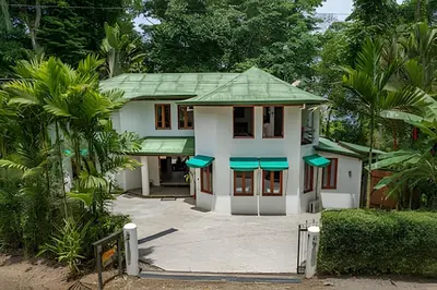 a small white house with a green roof at The Jungle Inn in Dominicalito