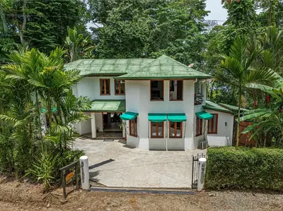 a white house with a green roof at The Jungle Inn in Dominicalito