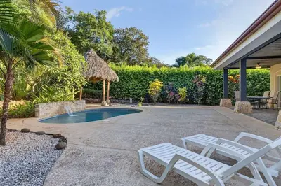 a patio with two white chairs and a swimming pool at Roca Blanca -Private Pool- Near To Conchal & Flamingo Beach in Brasilito