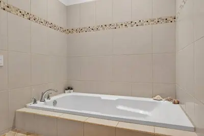 a white bath tub in a bathroom with tiles at Roca Blanca -Private Pool- Near To Conchal & Flamingo Beach in Brasilito